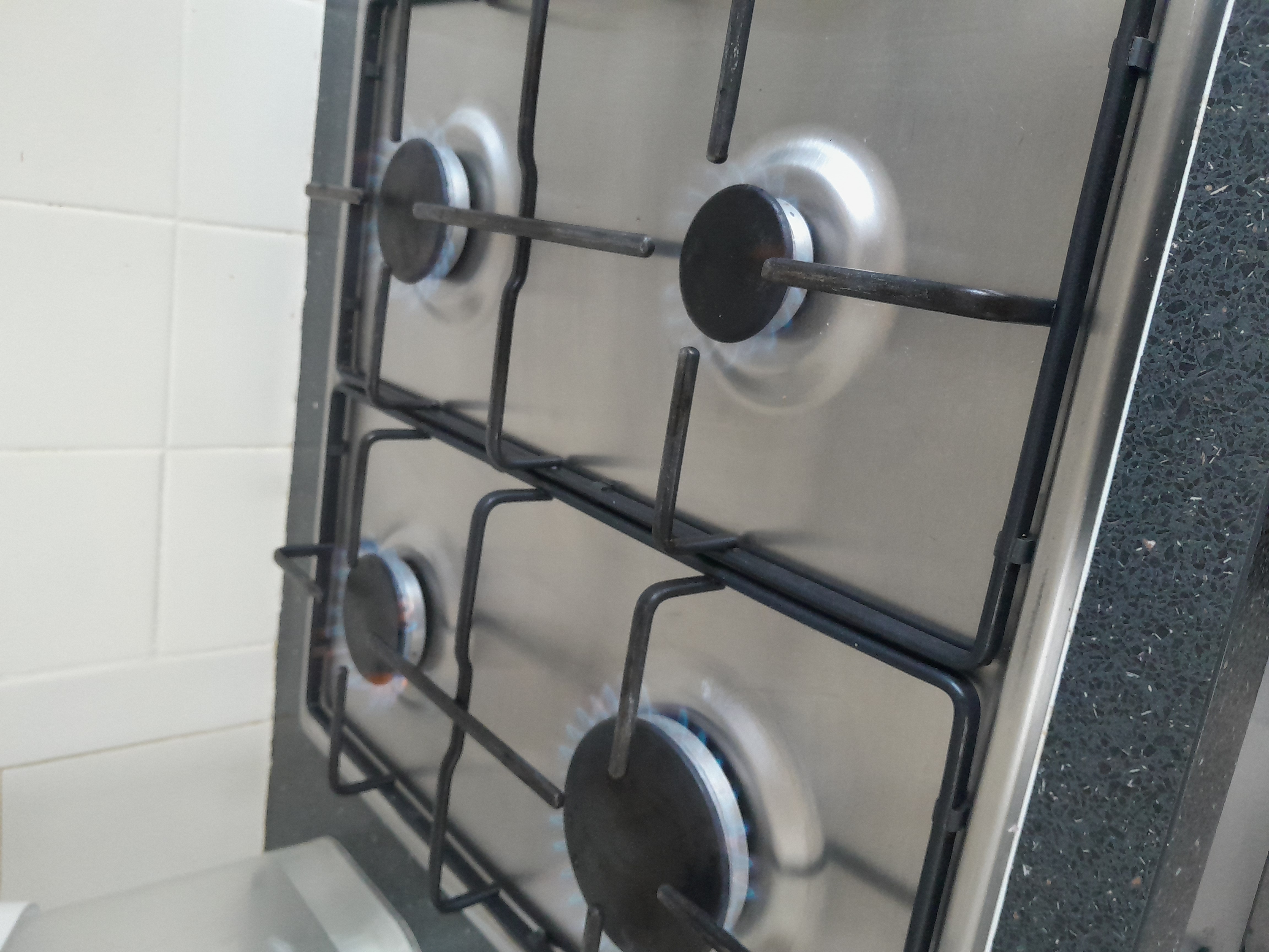 Gas hob flame checked for safe, correct combustion during a CP12 inspection