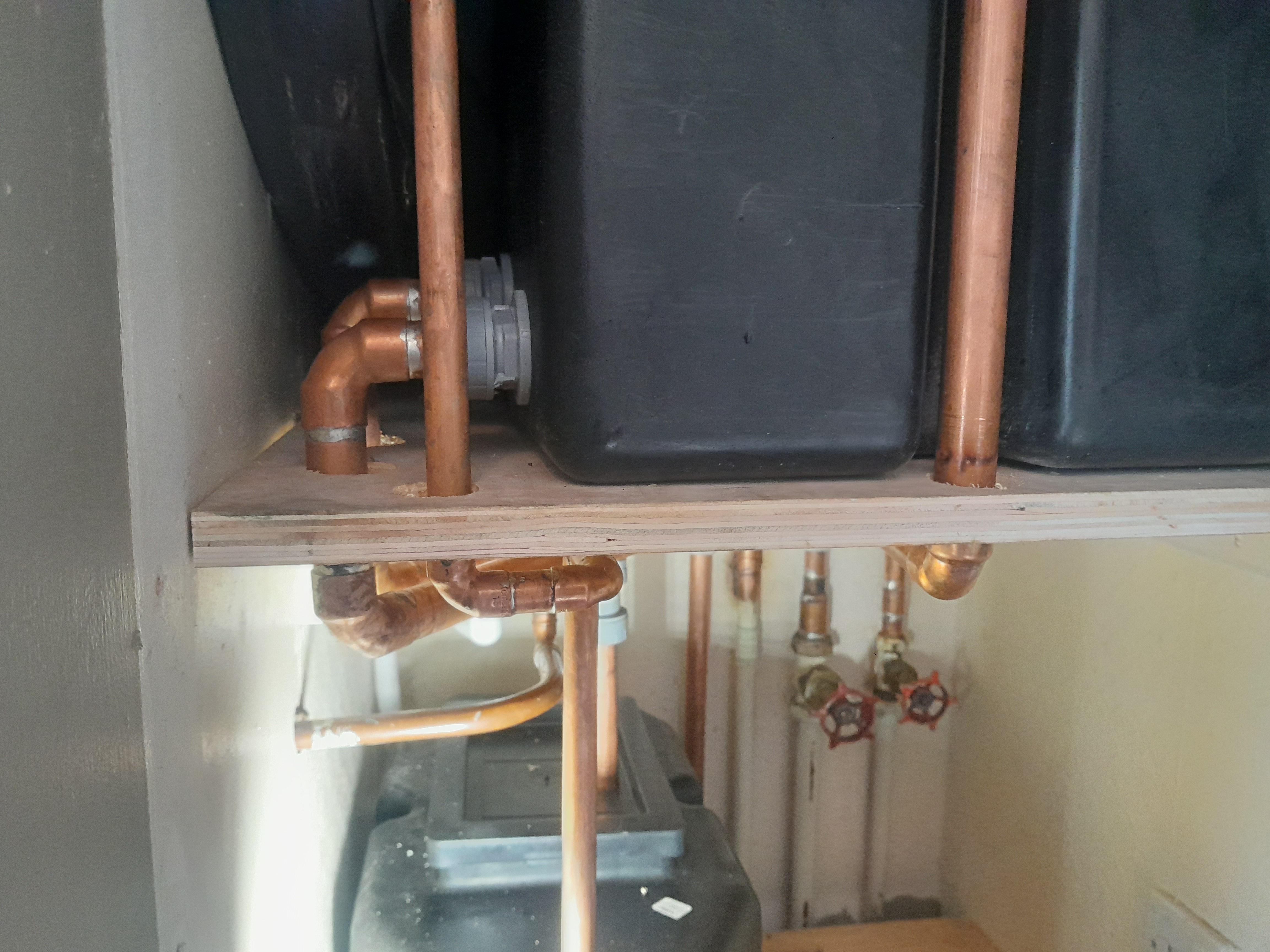 Copper pipework and isolation valves fitted above an unvented cylinder